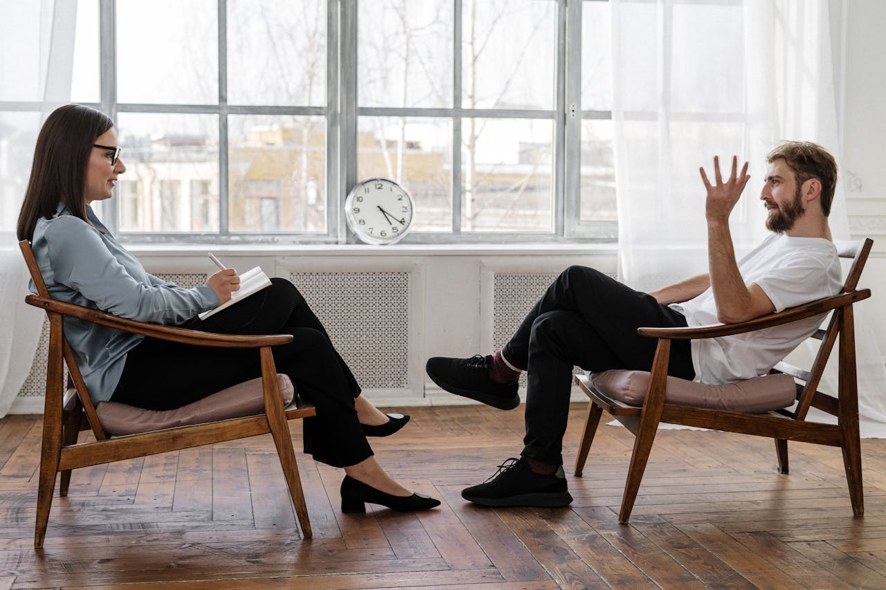 The Art of Drawing Readers In: Your attractive post title goes here A therapist engaging in a counseling session with a male patient to support mental health.